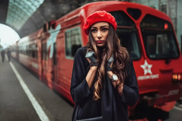 Chica en el abrigo y tomar en la estación de tren