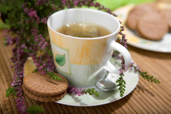 A cup of tea with cookies on a background of flowers