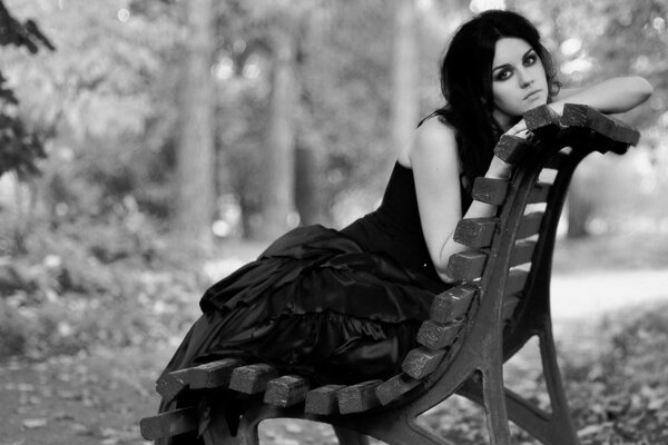 Nostalgic black and white photo - a girl on a park bench