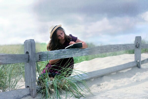 A girl reading a book on the fence