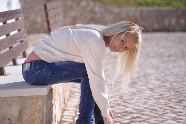 Fille sexy en jeans voit sur le banc