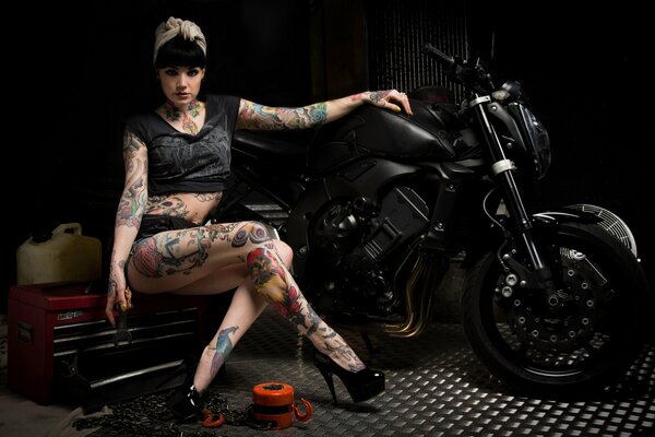 Mädchen mit Tattoos am Motorrad