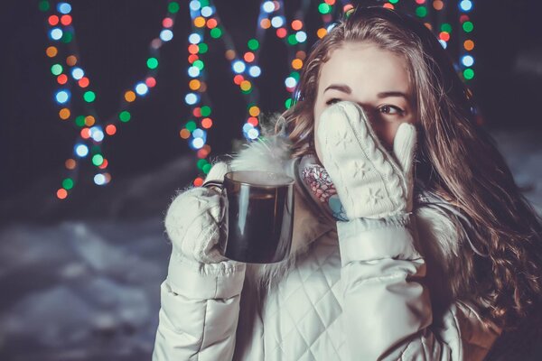 Chica con una taza de bebida caliente en el clima invernal