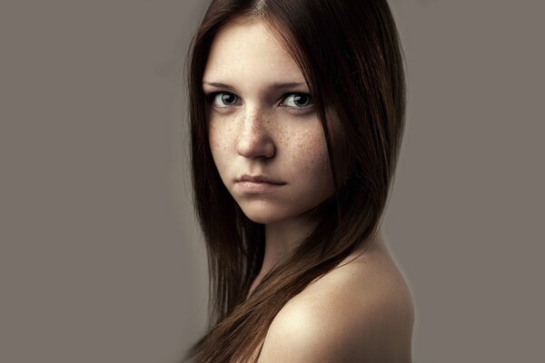 Portrait photo of a girl with a beautiful look and freckles