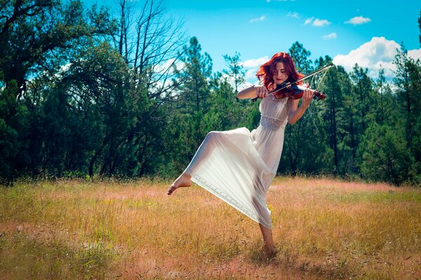 A violinist girl is dancing on the field