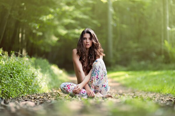 The girl is sitting among the greenery