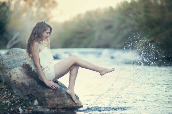 The mermaid has come ashore and is sitting on a rock