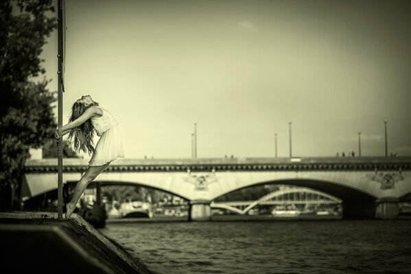 Foto eines anmutigen Mädchens auf dem Hintergrund einer Brücke