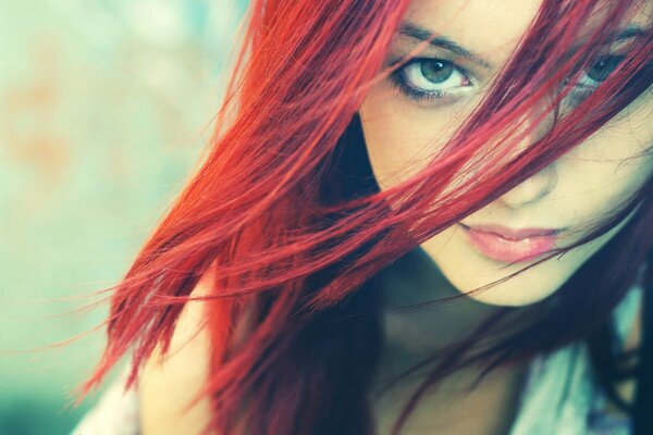 Visage de fille avec des cheveux rouges et un regard mystérieux