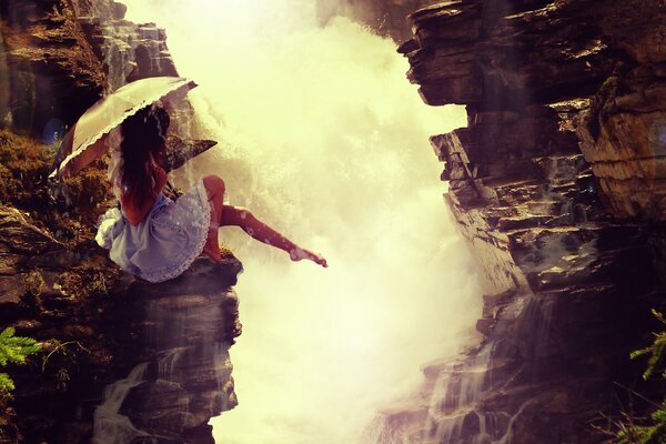 Une fille avec un parapluie est venu voir la cascade