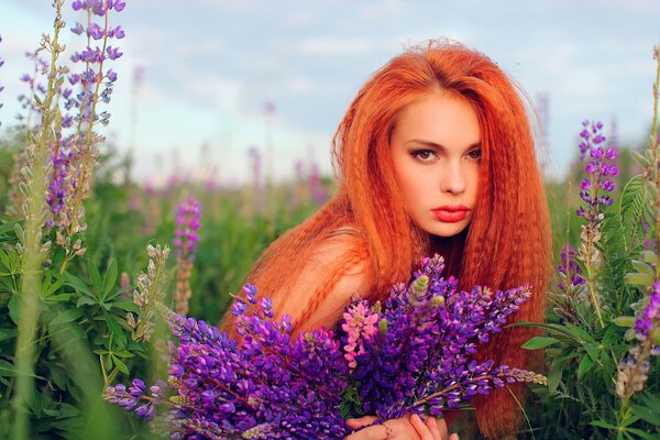 Rothaarige Mädchen mit einem durchdringenden Blick in Blumen