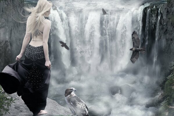 A girl in a black dress on the background of a waterfall