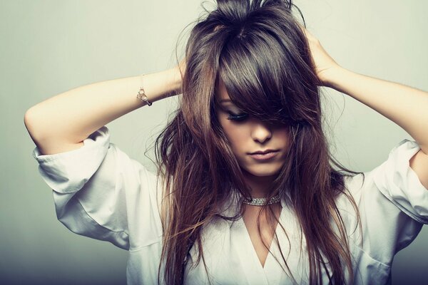 A photo of a beautiful girl with her hair in her hands