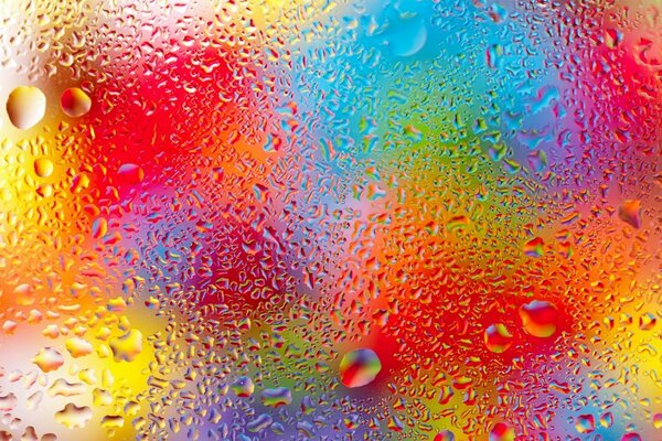 Regenbogentropfen auf nassem Glas