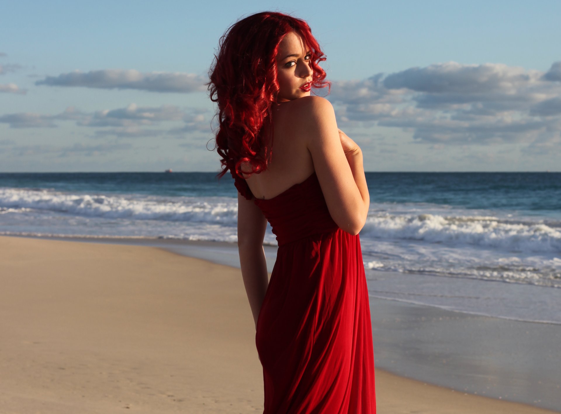 girl red dress red hair face view sea waves beach