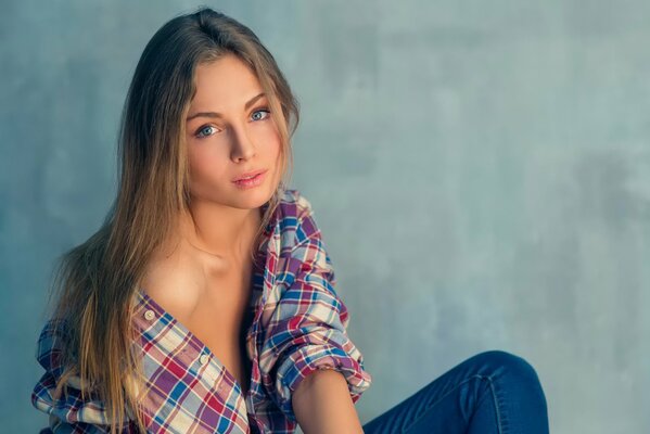 Ritratto di una ragazza dai capelli lunghi in camicia a quadri e jeans