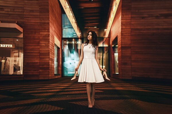 Morena chica en vestido blanco con zapatos