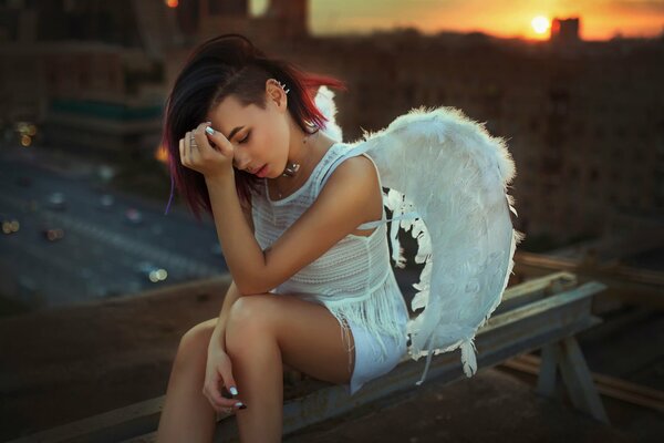 Fille dans le rôle d un ange est assis sur le fond de la route