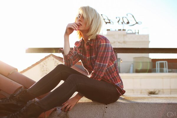 Blonde Mädchen auf dem Dach des Hauses