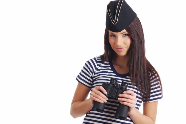 Jeune fille dans un marin rayé avec des jumelles dans les mains