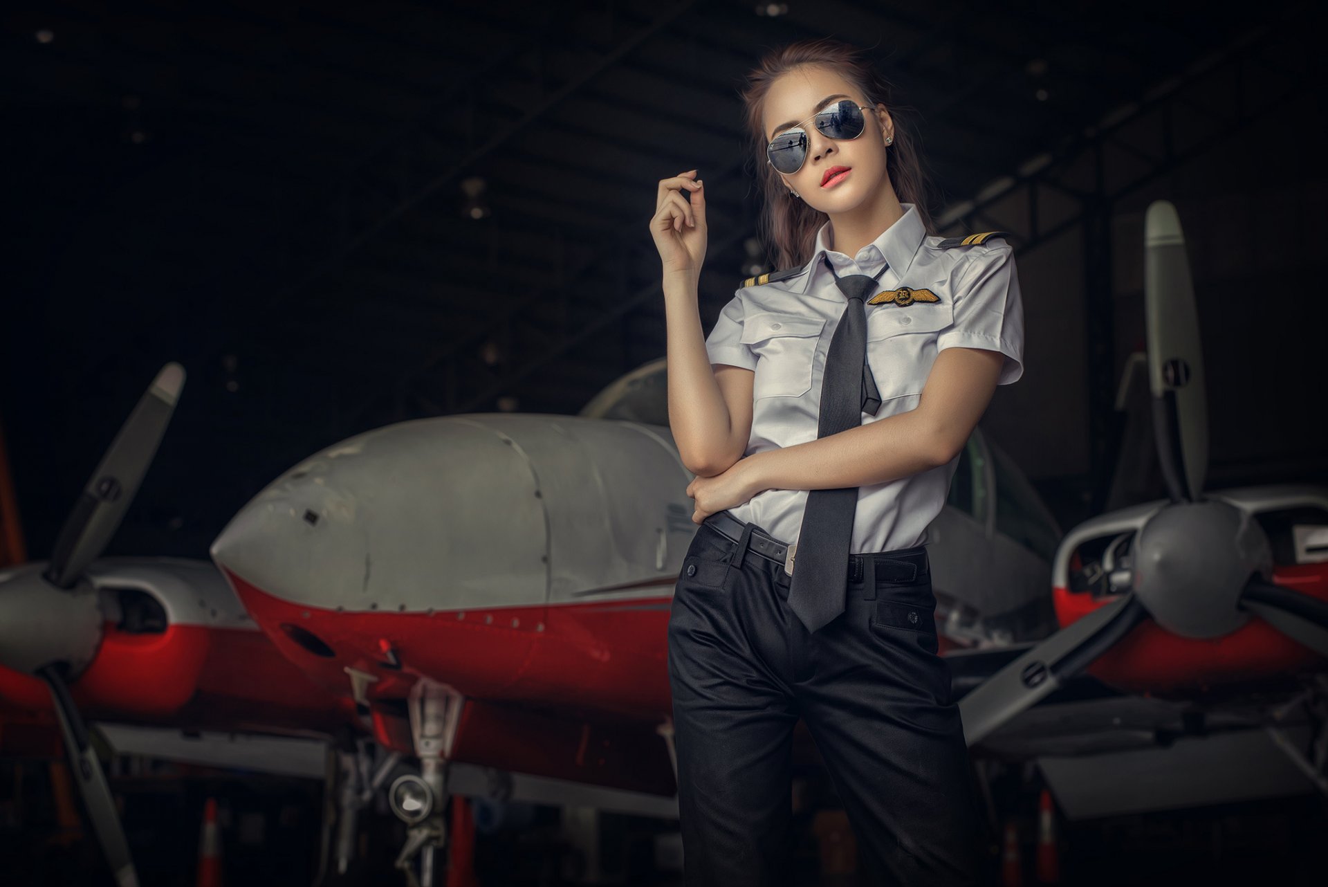 chica uniforme gafas avión hangar