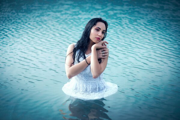 Mädchen im Kleid steht im Wasser