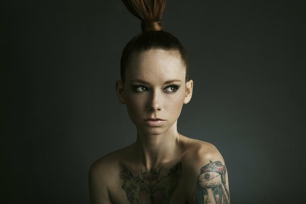 Portrait of a model girl with a tattoo on her arms and collarbone