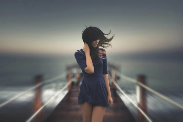 Mädchen am Pier, im Wind, lockere Haare