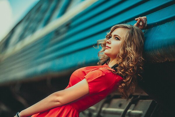 Kompozycja dziewczyna w czerwonej sukience na tle pociągu