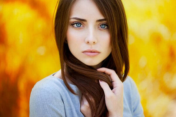 A red-haired girl with blue eyes on a golden-yellow background