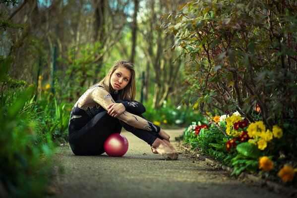 Photo of a rhythmic gymnast with a ball in the garden