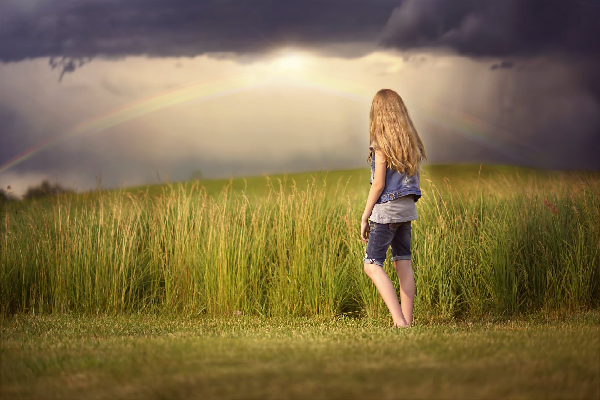 girl rainbow clouds the field
