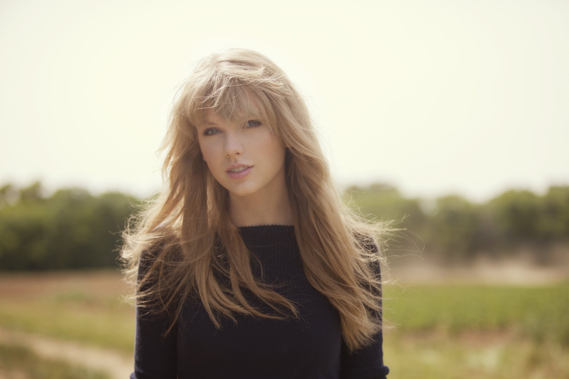 taylor swift blonde chanteuse visage regard cheveux soleil fond