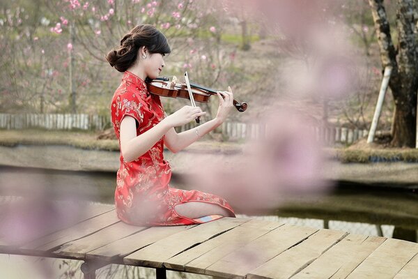 Chica tocando el violín en primavera