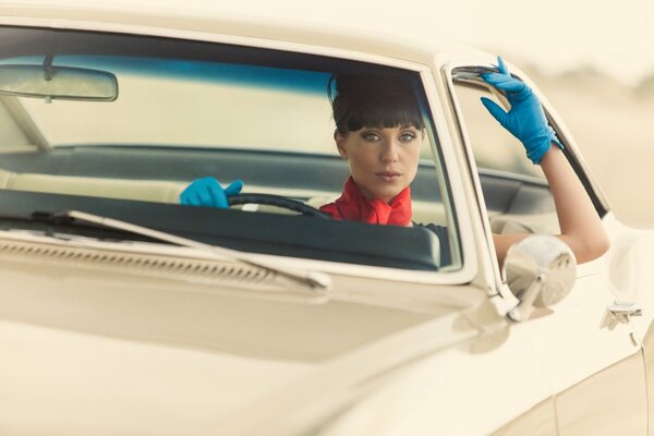 A girl in gloves on a car