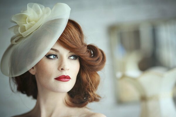 Hermosa chica con el pelo rojo en el sombrero