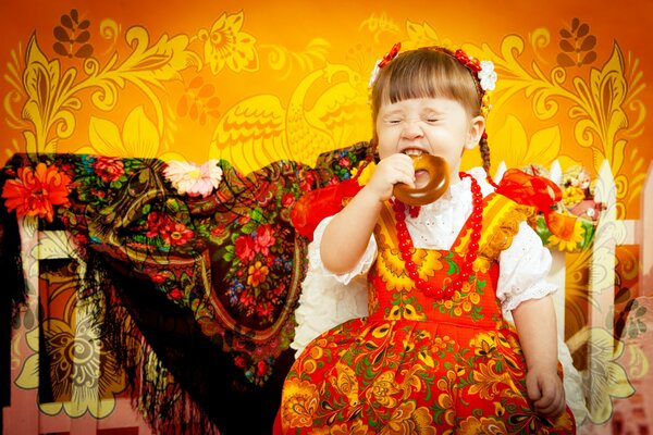 Studio-Foto eines Mädchens in traditioneller russischer Kleidung vor einem Hintergrund von Chochloma