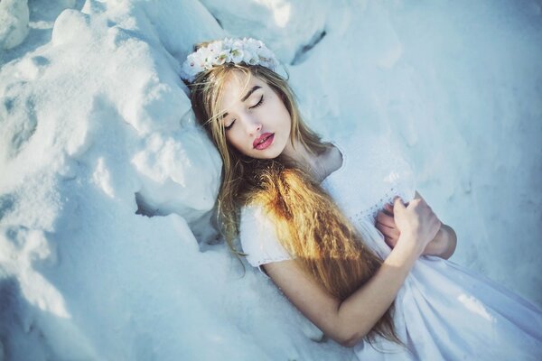 Ragazza addormentata in inverno sulla neve