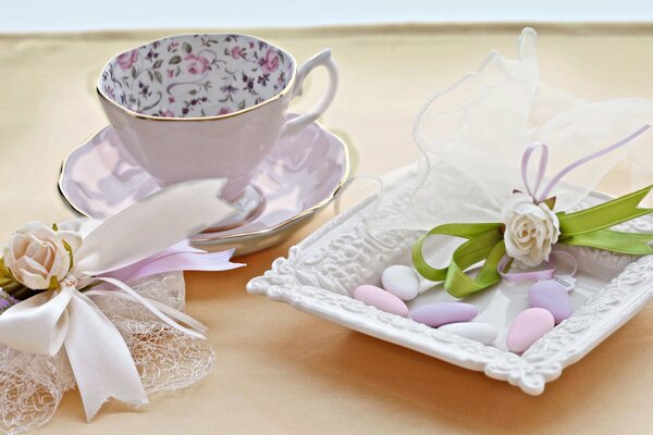 Delicious still life with a teacup, flowers and sweets