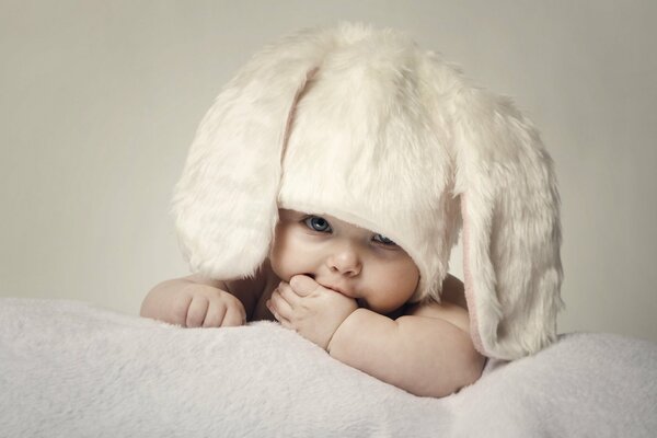 Маленький ребёнок в шапке зайчика с ушами