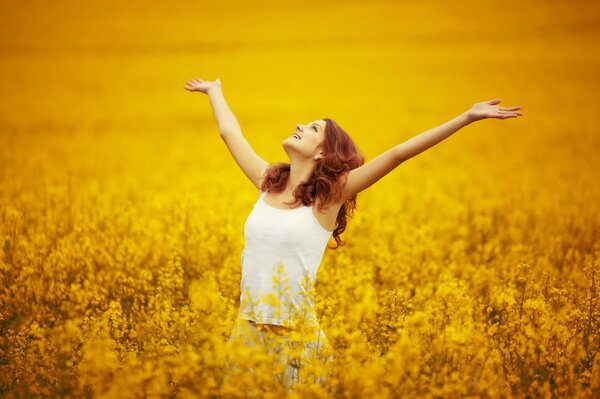 A girl in nature rejoices and smiles