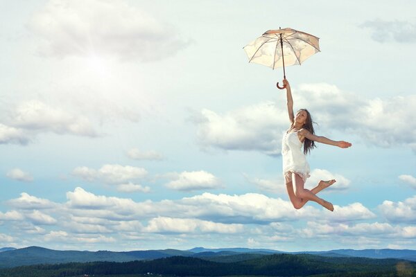 A girl hovers in the air on an umbrella