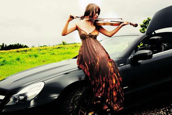 Playing the violin on the hood of the car