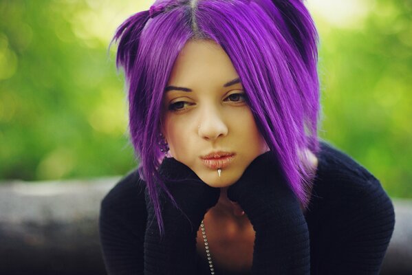 La mirada de una chica con cabello morado y piercings