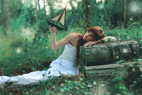 A girl with a boat on the background of a forest