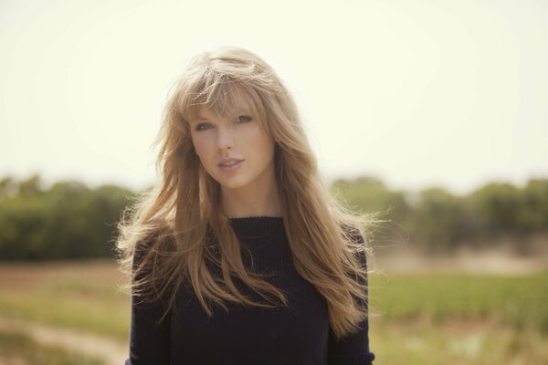 Blonde girl looks at the background of the sun