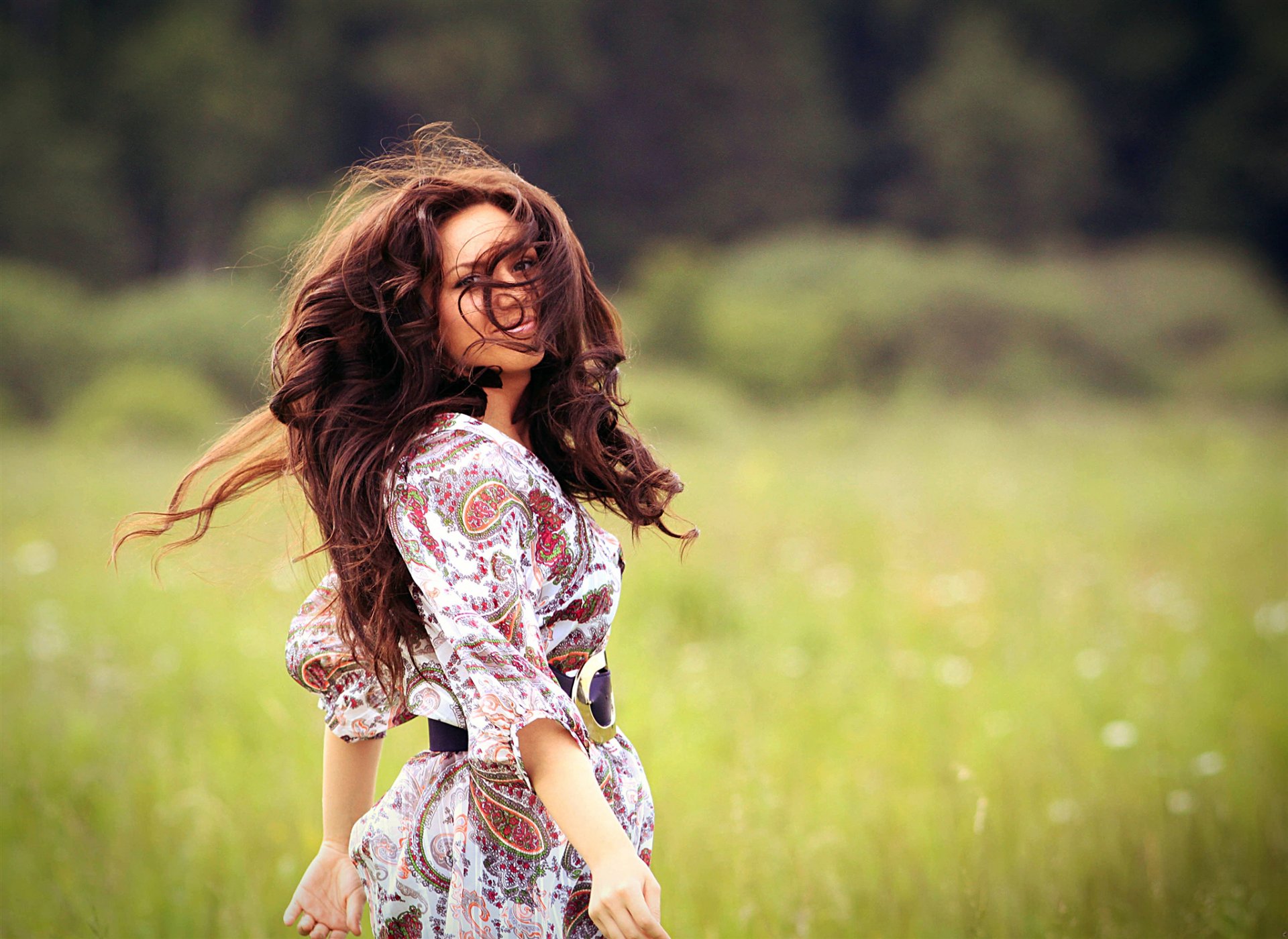 ragazza capelli castani riccioli capelli sorriso natura campo erba