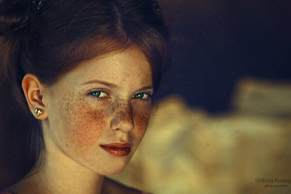 A red-haired girl with green eyes and freckles