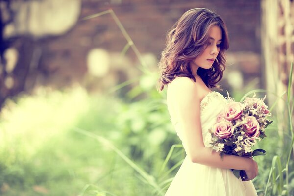 Die Braut mit Blumen wird in der Natur fotografiert