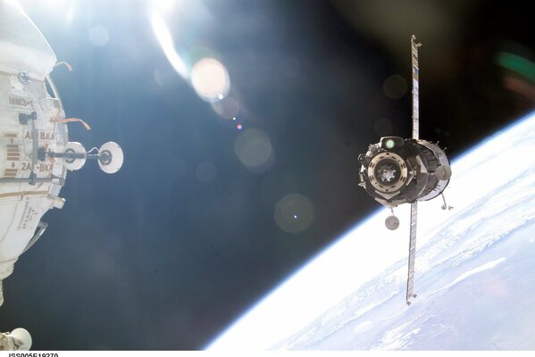 Atraque de koroble con la ISS en el espacio, en el fondo de la tierra